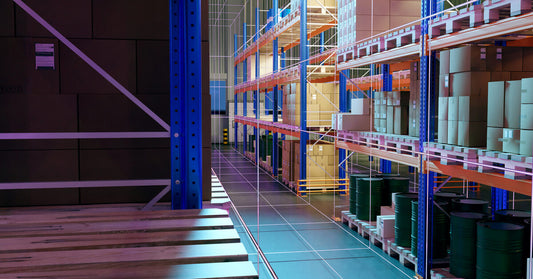 A warehouse that includes several multi-tier pallet racking systems that store brown cardboard boxes and goods.