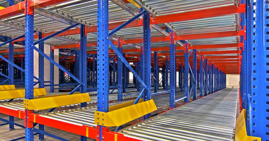 A close-up view of metal racking systems and shelving solutions that have blue, red, and yellow parts.