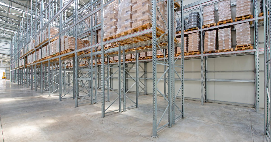 Several rows of neatly arranged vertical metal shelving racks holding stacks of pallets in a facility.