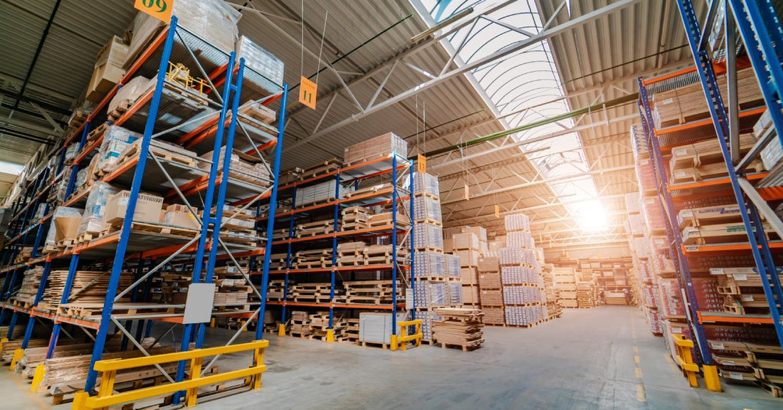 A warehouse with several pallet racking systems installed. Each rack stores wooden pallets and goods.