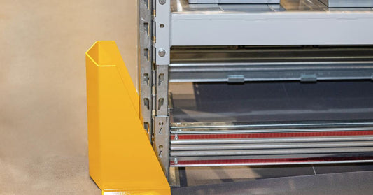 The bottom part of a pallet rack shelving unit. There is a yellow corner protector around the leg of it.