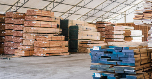 Multiple stacks of wooden planks are arranged around the space. All of the stacks are away from the walkway.