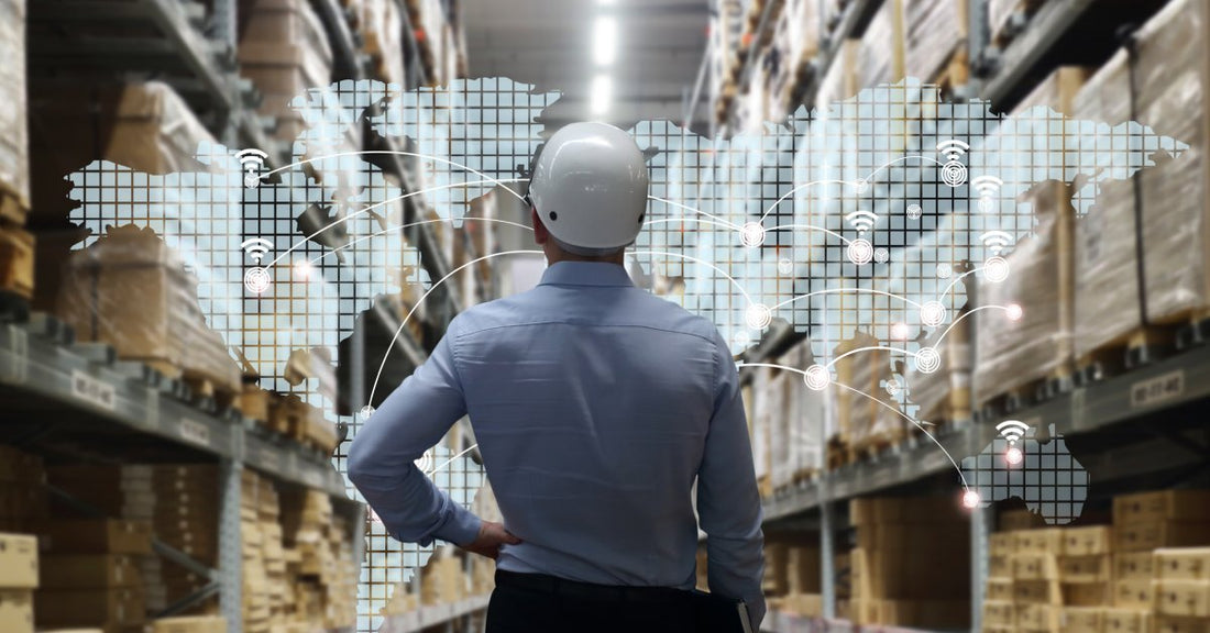 A man with a hard hat on, looking out at shelving units. Overlayed on the shelves is an outline of the world.