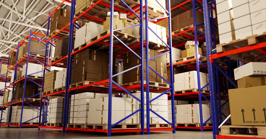 A clean, well-lit warehouse, with boxes neatly organized on the shelves of a blue-and-orange racking system.